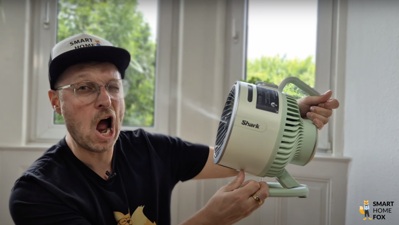 Der Smart Home Fox Experte demonstriert einen kompakten Akku-Ventilator mit Sprühnebel-Funktion und sprüht sich zur Abkühlung Wasser ins Gesicht.